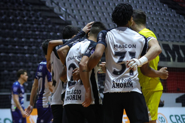 Jogadores do Corinthians em quadra durante partida de futsal no Ginásio Wlamir Marques.